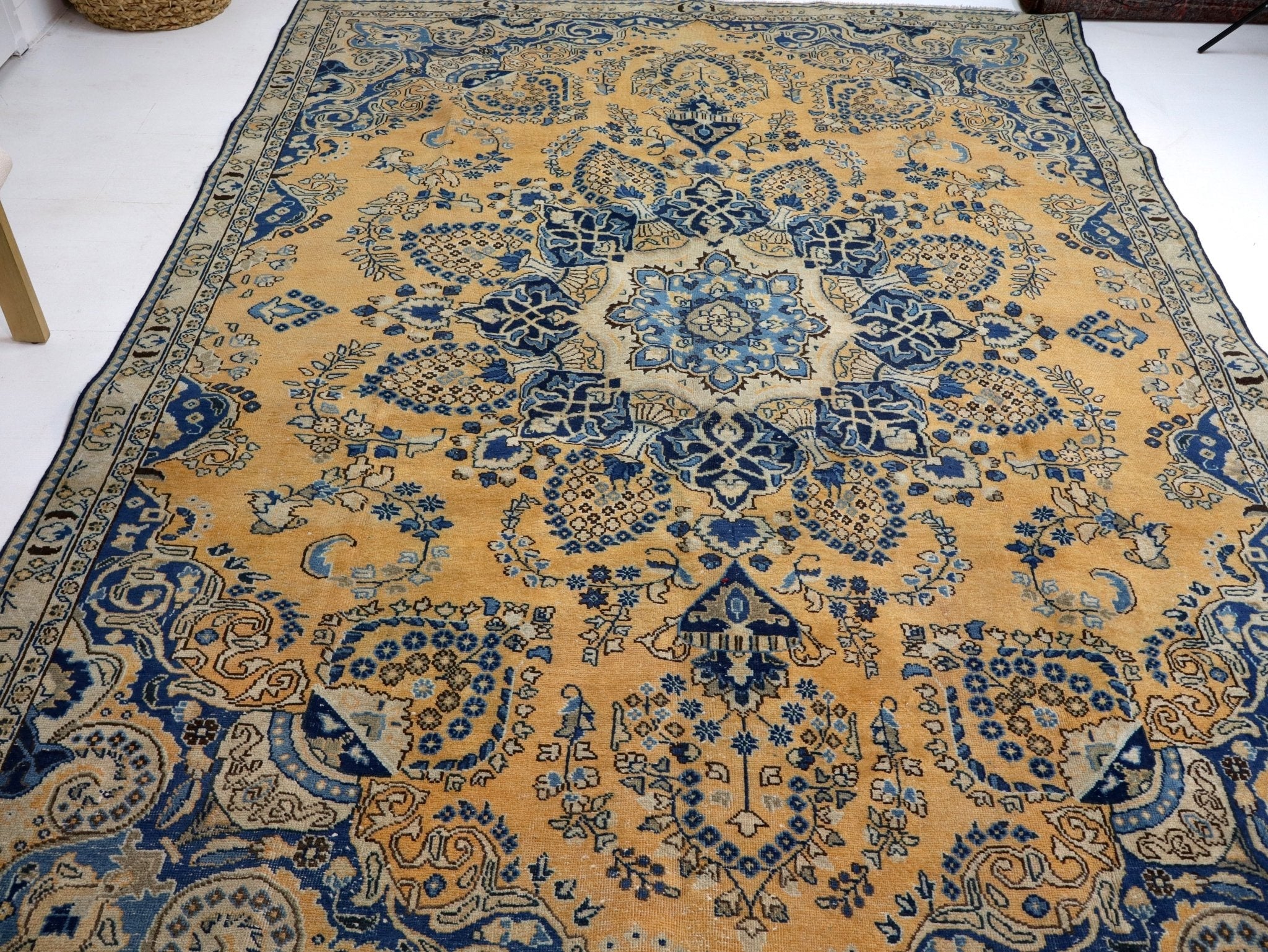 Persian-style rug wide view with blue floral lattice pattern on tan field