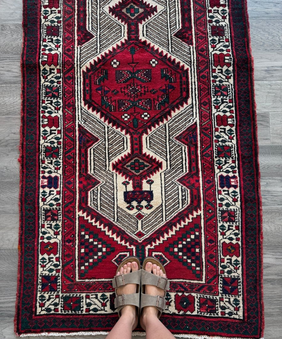 Red, cream, and navy patterned Persian-style runner rug with geometric medallion center
