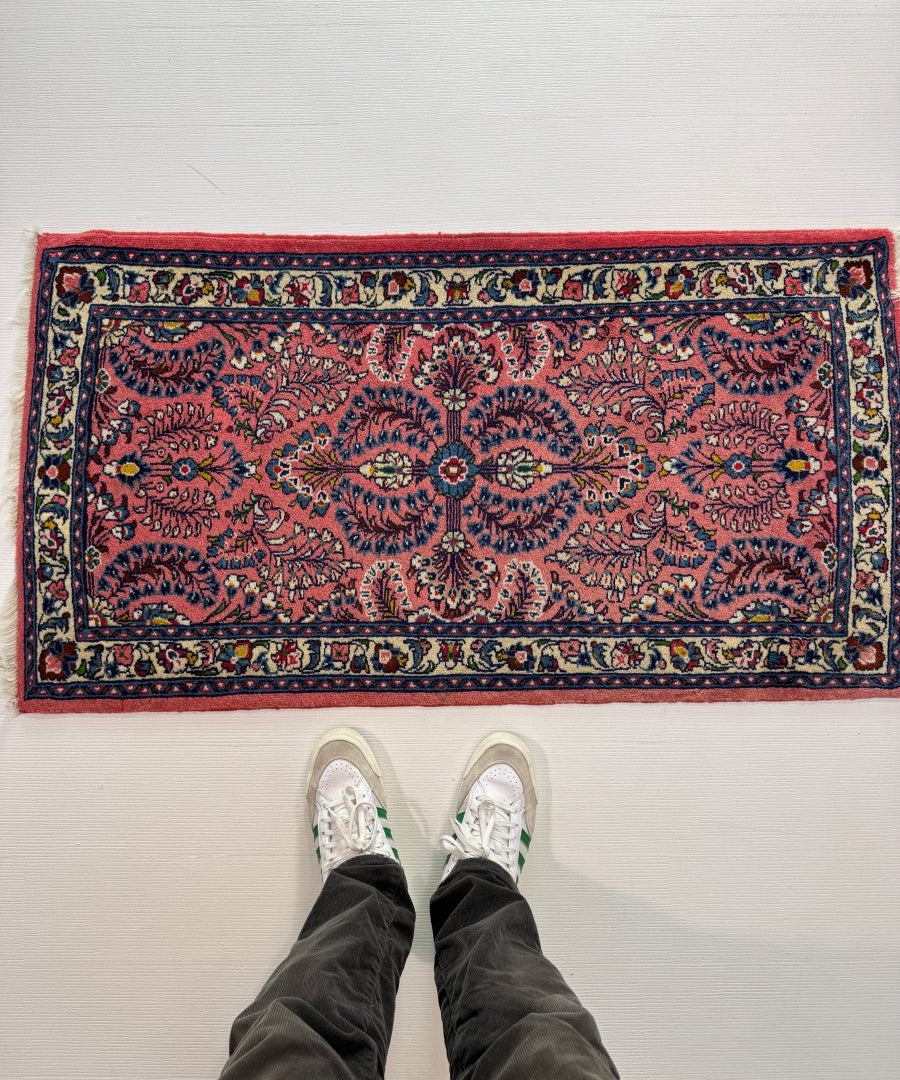 Persian Sarouk rug with red field and ornate navy border, flat woven design