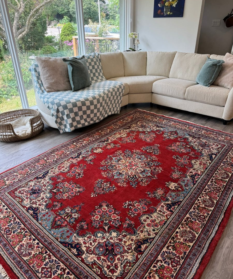 Red Persian Sarouk rug with ornate medallion and decorative corner motifs, flat border.
