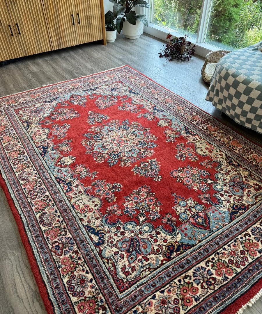 Red Persian Sarouk rug with symmetrical floral medallions and ornate edge border.