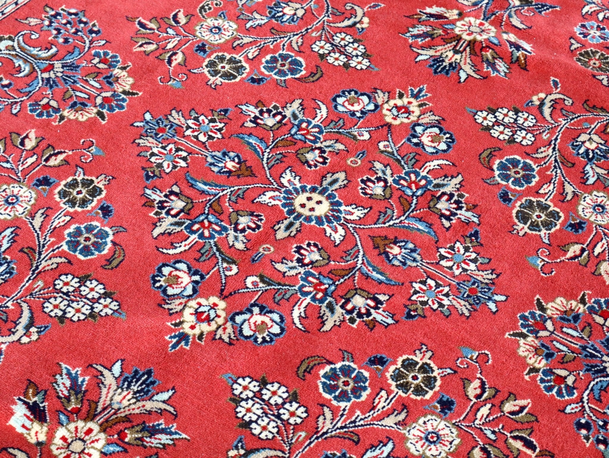 Persian Sarouk rug, red field with dense floral medallion pattern and dark navy accents