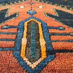 Orange, teal, and navy geometric pattern on Persian runner rug with diamond accents