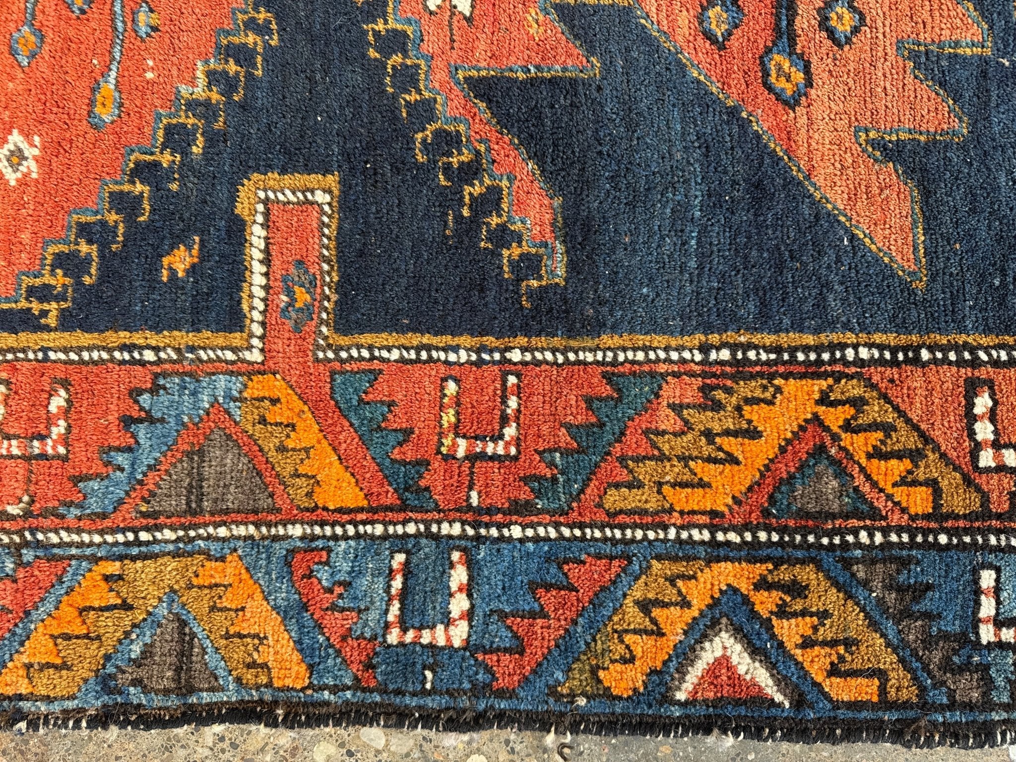 Persian runner rug decorative band with orange, navy, and yellow triangle and arrow motifs