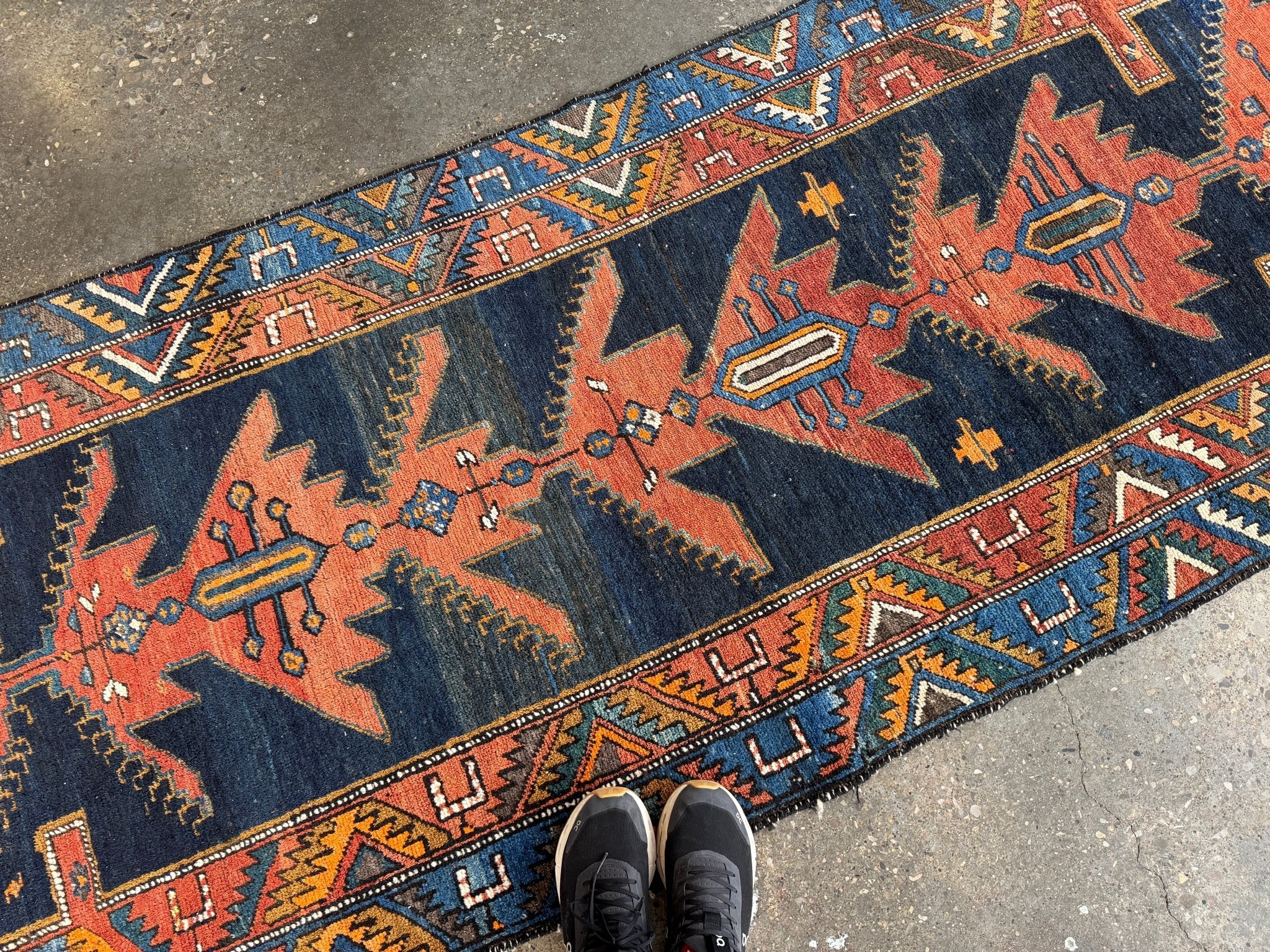 Runner rug with navy blue field and rust-orange star and diamond pattern border