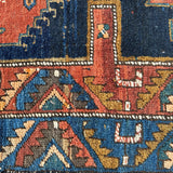 Close-up of Persian runner rug border with red, navy, teal, and cream repeating shapes