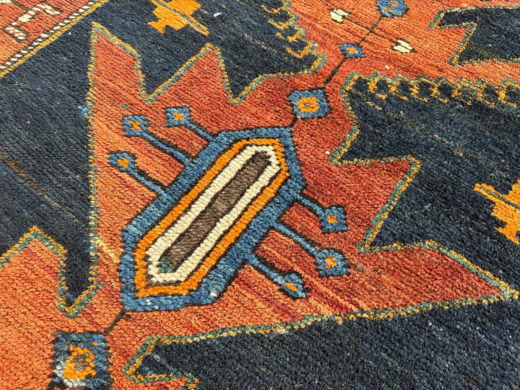 Geometric Persian runner rug motif in orange, teal, and navy with cream-lined shapes