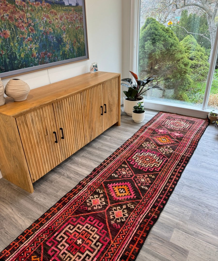 Runner rug with red and dark navy geometric medallions and bordered pattern; short ends.
