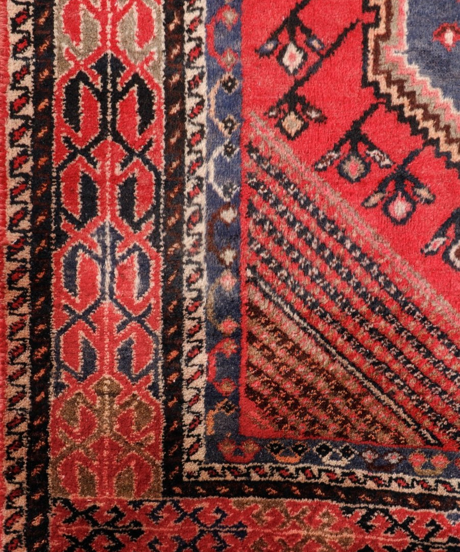 Persian Shahreh-Babak rug border close-up with red, cream and dark blue zigzag pattern
