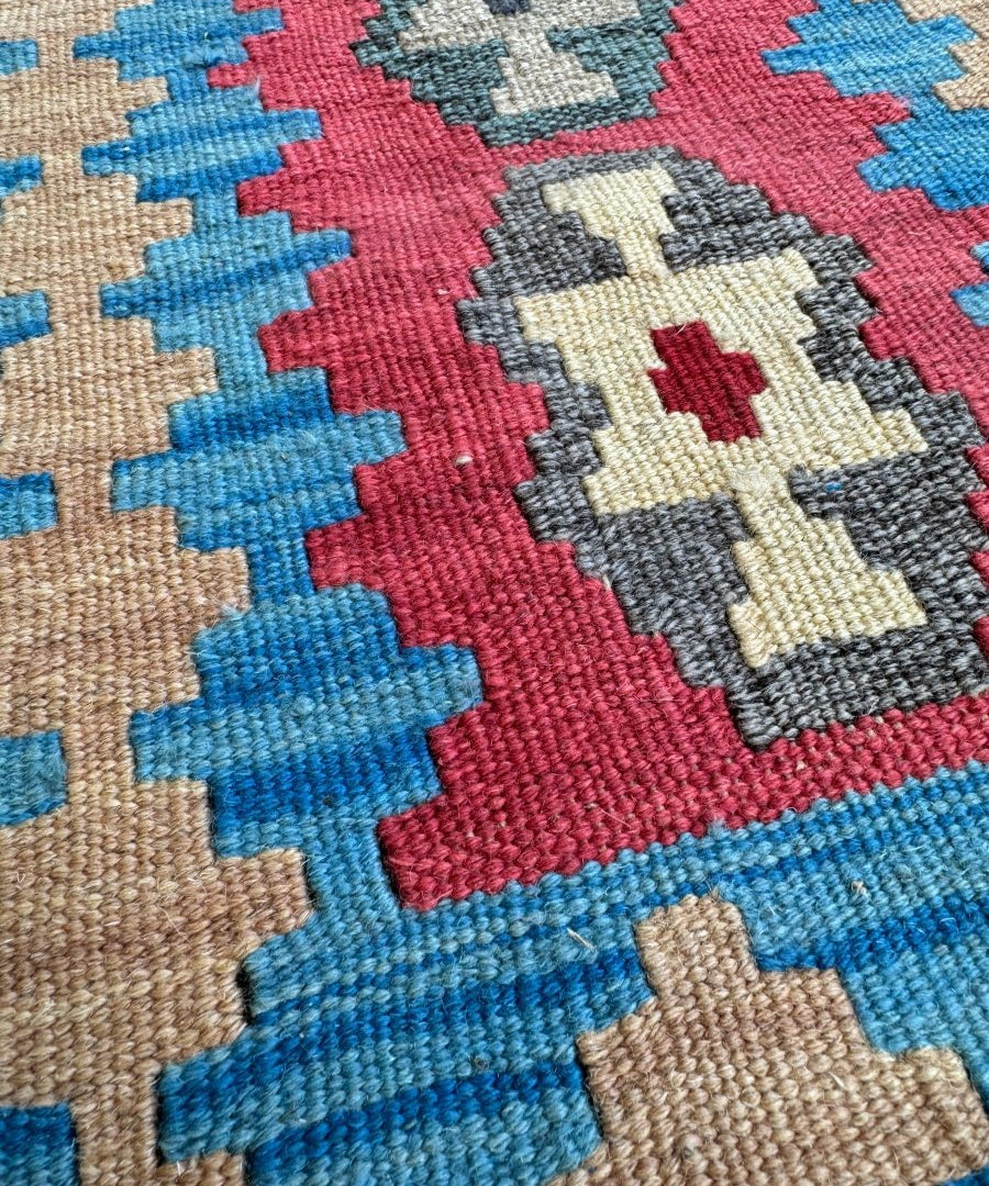 Persian Shiraz kilim rug close-up of red and blue geometric crosses with cream accents
