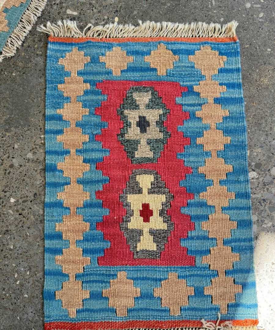Persian Shiraz kilim rug with blue field, red medallion, and beige cross motifs