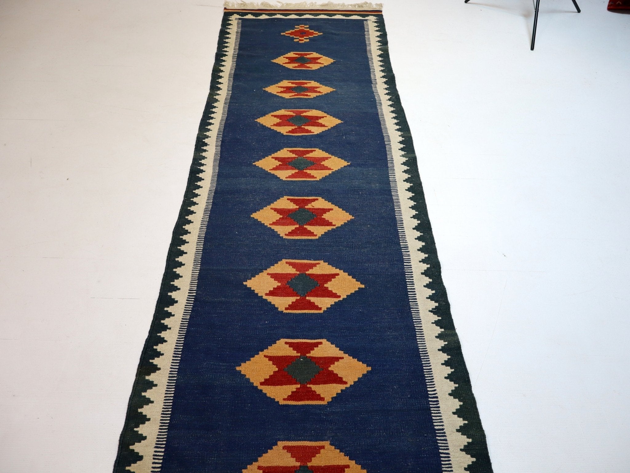 Blue kilim runner with geometric diamond medallions and cream border