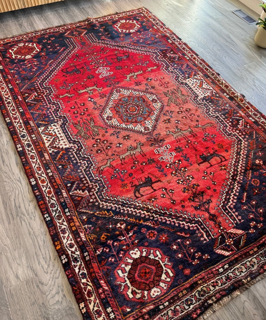 Persian Shiraz rug with red central medallion and navy border, detailed geometric patterns