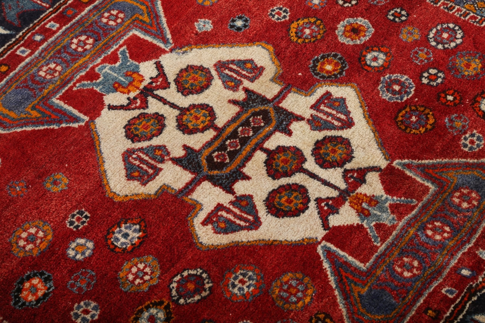 Persian-style rug top medallion close-up with cream geometric star and red surround