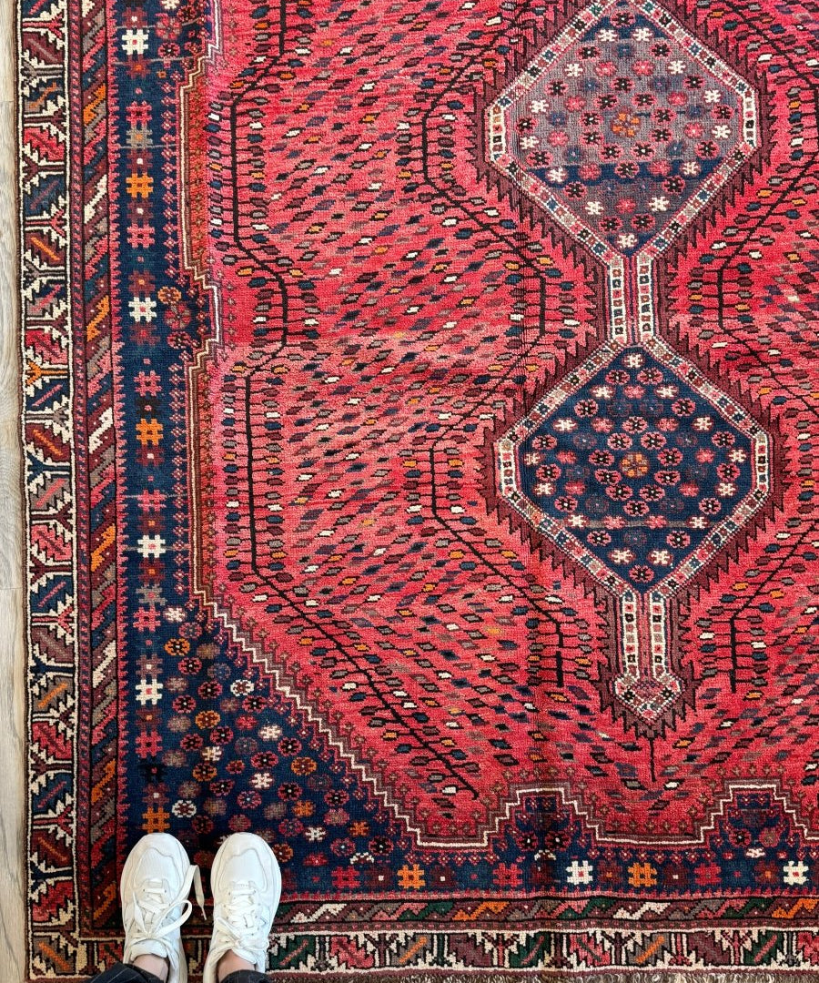 Persian Shiraz rug with red field and navy blue floral medallions, geometric border