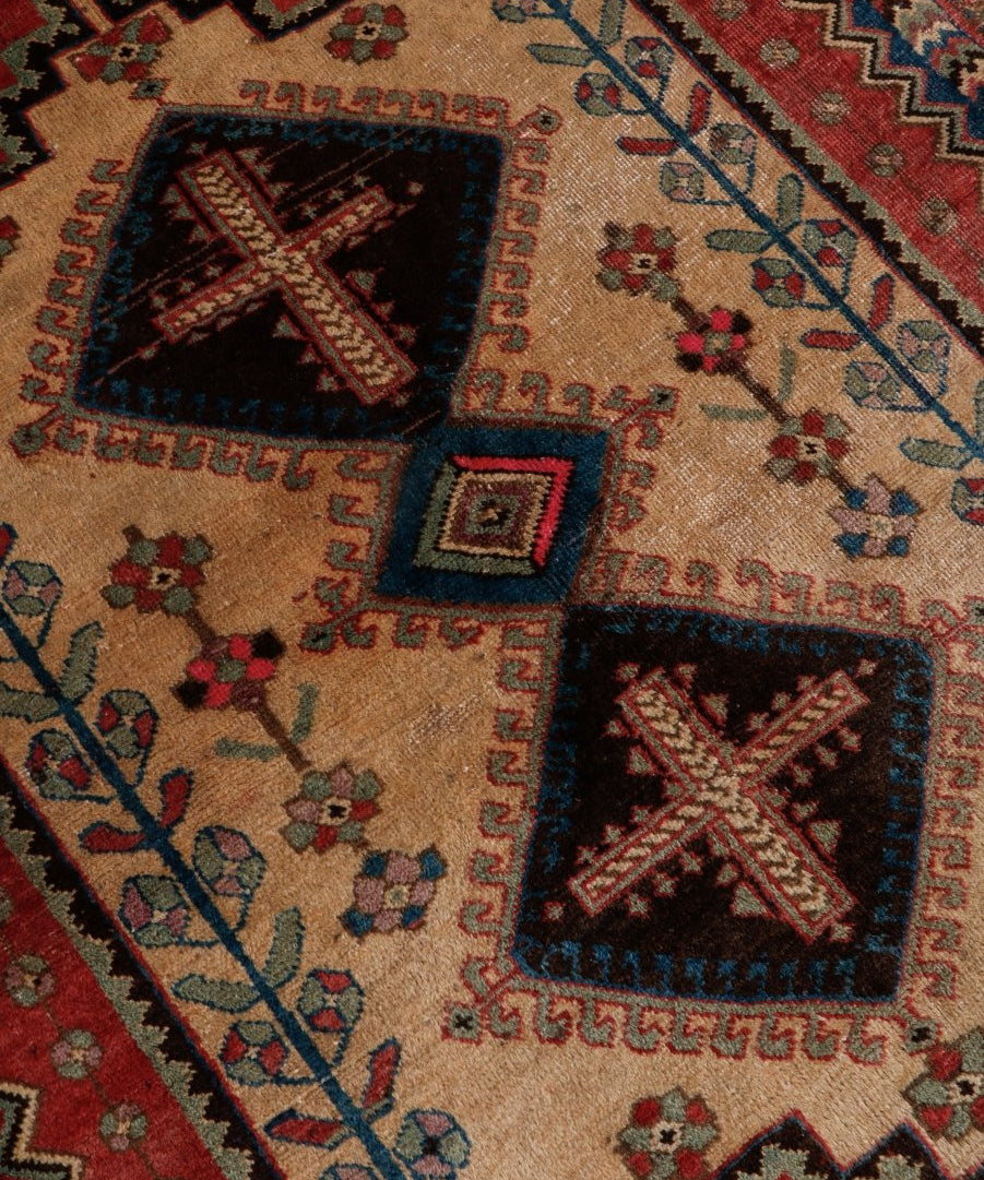 Persian Afshar rug close-up with cream ground, navy and red cross motifs