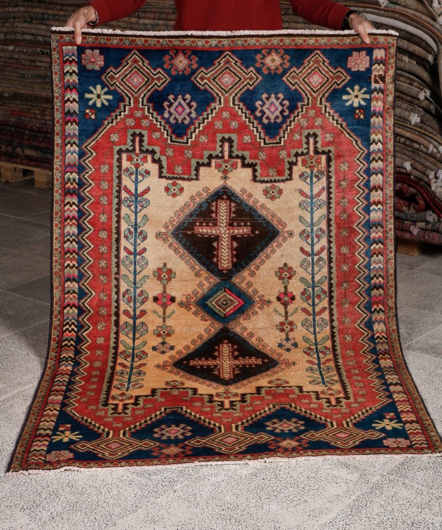 Persian Afshar rug laid flat, cream ground with red borders and navy diamond pattern