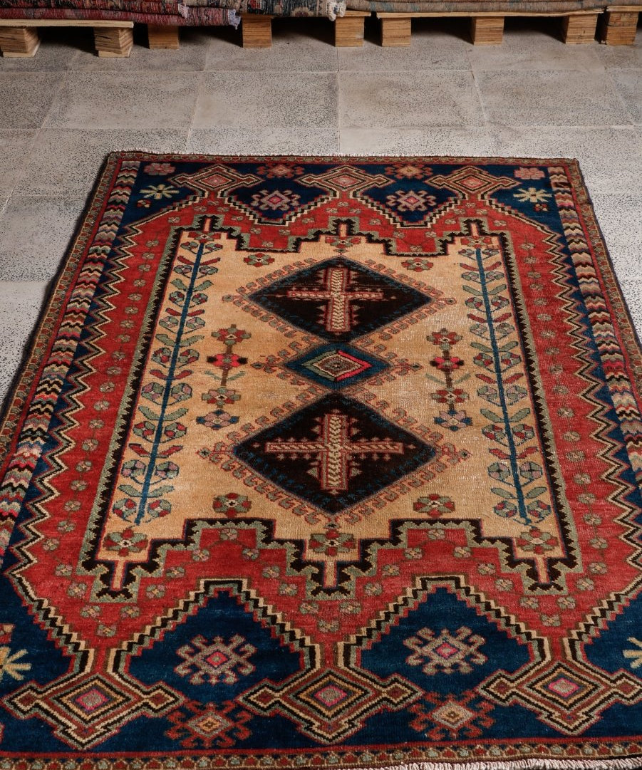 Persian Afshar rug with red border, cream center, and navy geometric corner pattern
