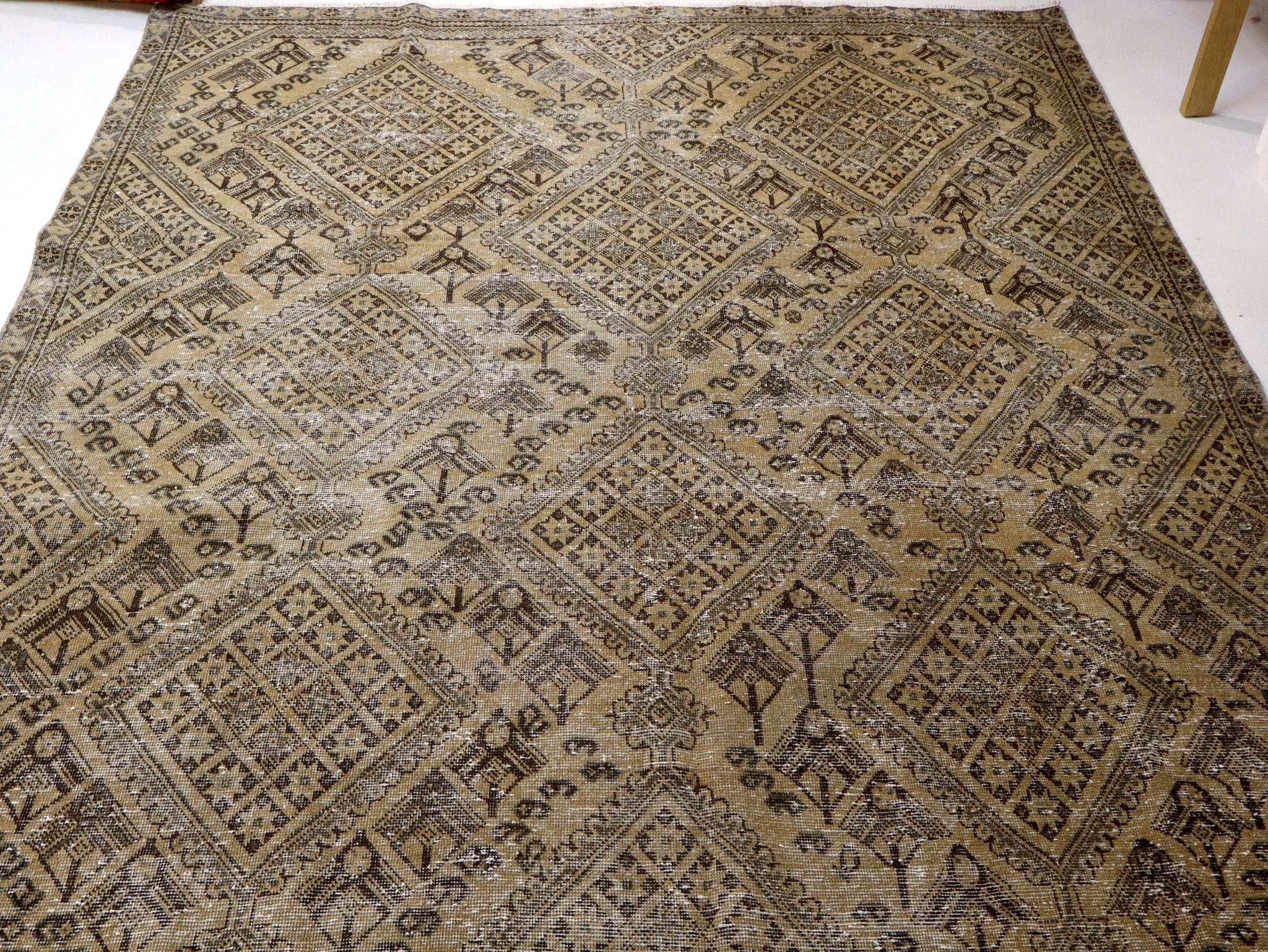 Beige and dark rug with central diamond medallion and bordered panels