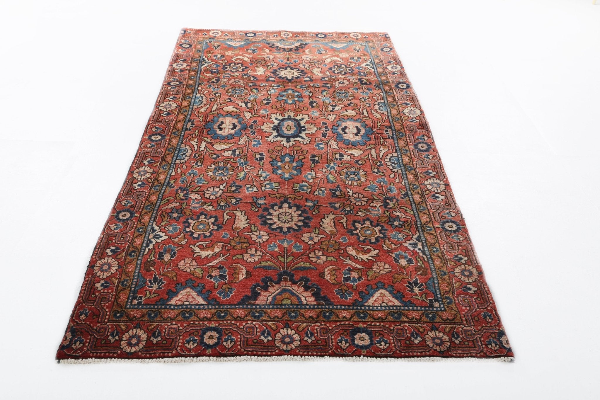 Persian-style runner rug full view with rust red field, navy border, and medallion motifs