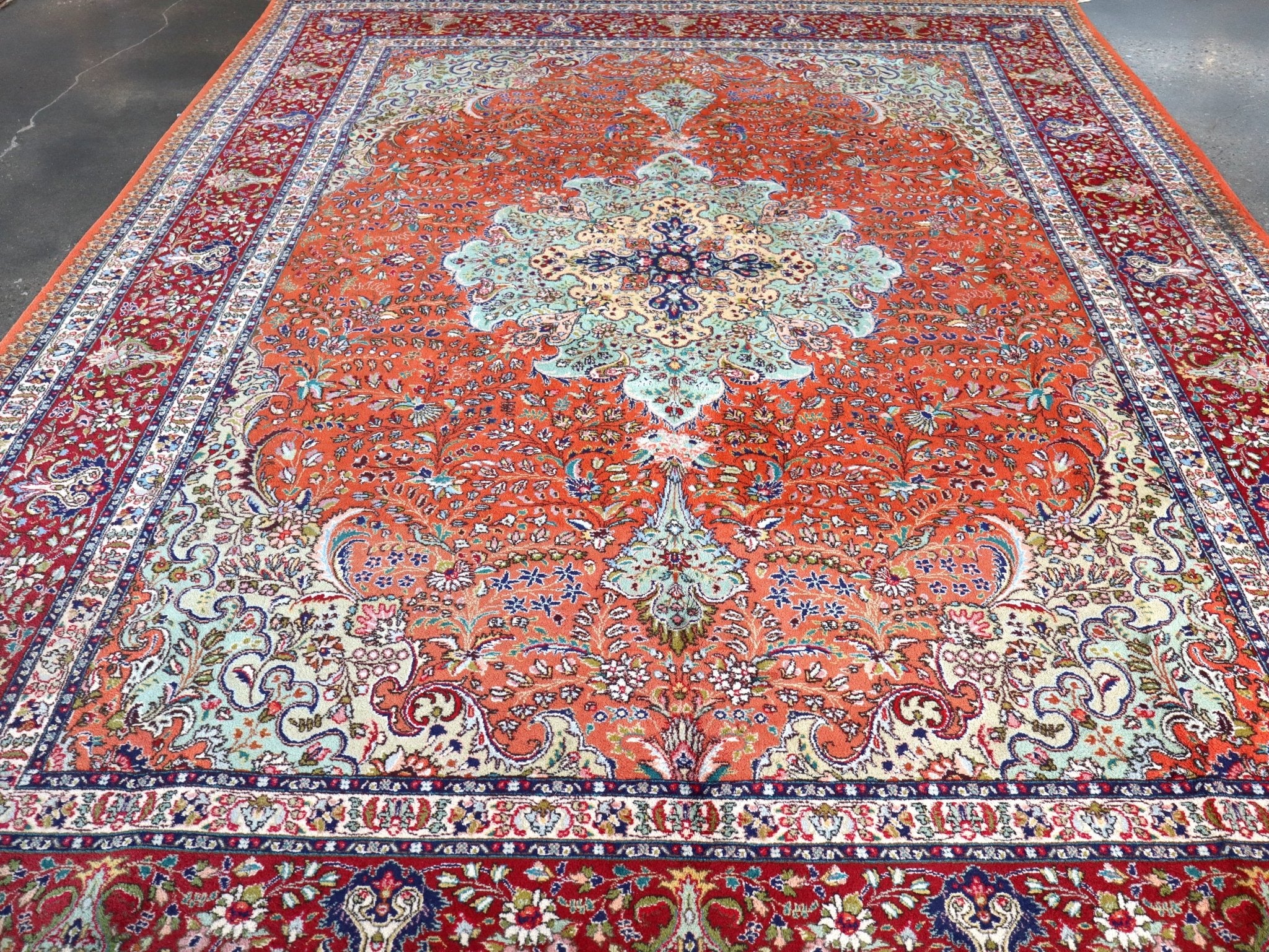 Rug with red-orange field, central cream medallion, and symmetrical blue floral border.