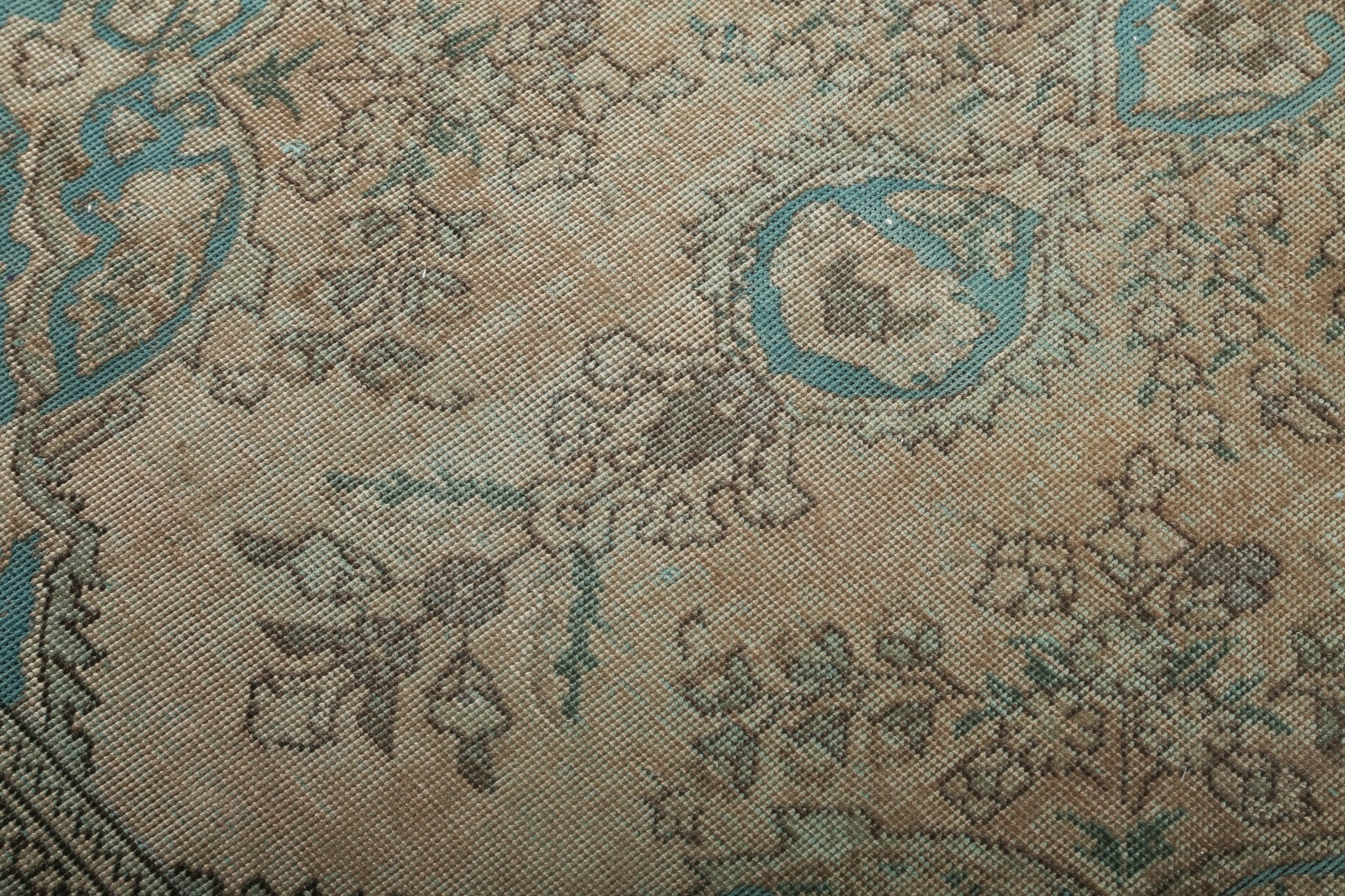 Persian Tabriz rug texture close-up with beige background and teal emblem details