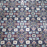 Persian Tabriz rug close-up with repeating small diamond and floral motifs