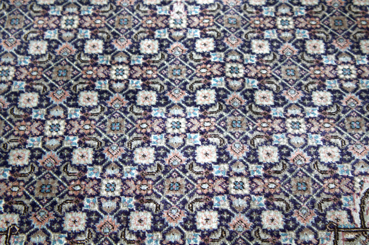 Persian Tabriz rug close-up with repeating small diamond and floral motifs