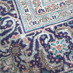 Persian Tabriz rug close-up of dark blue and tan corner motif
