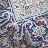 Persian Tabriz rug close-up of dark blue and tan corner motif