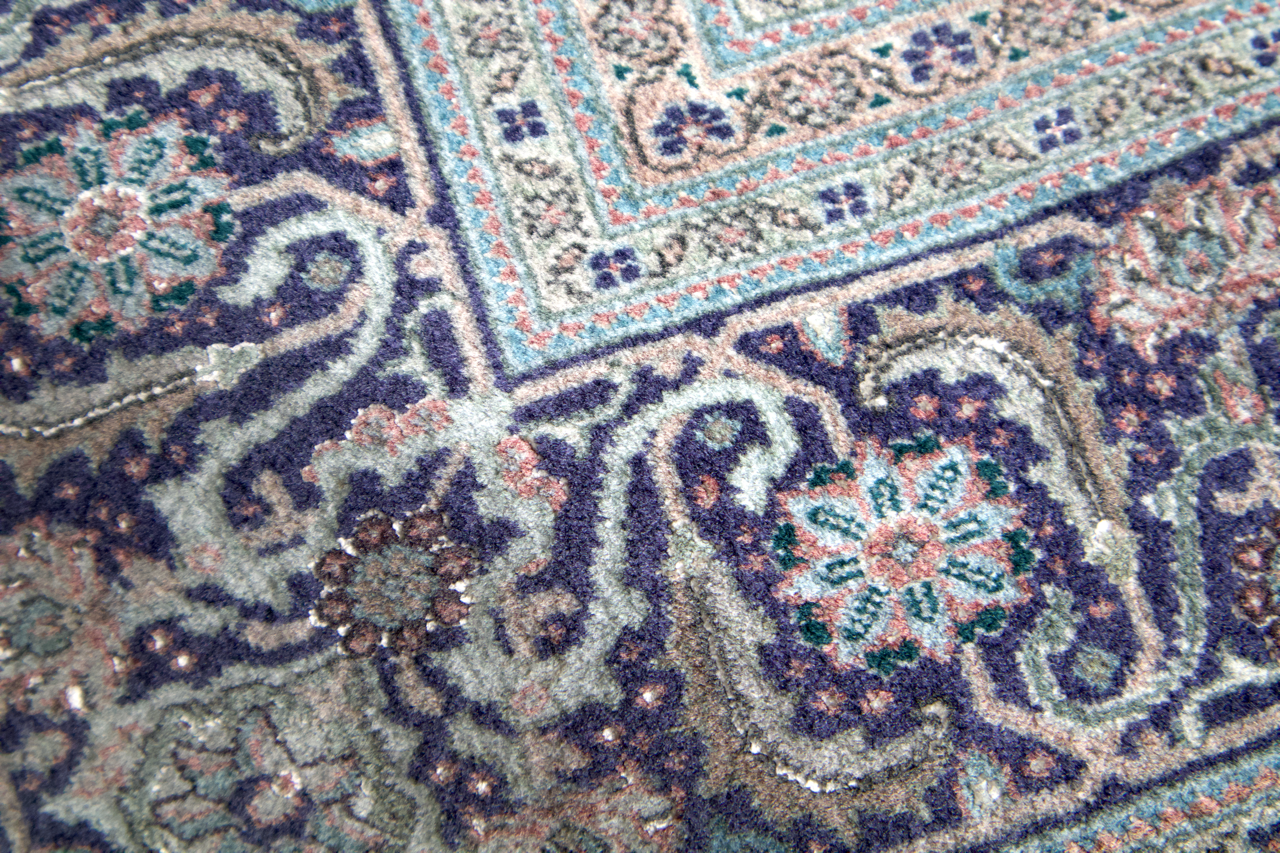Persian Tabriz rug close-up of dark blue and tan corner motif