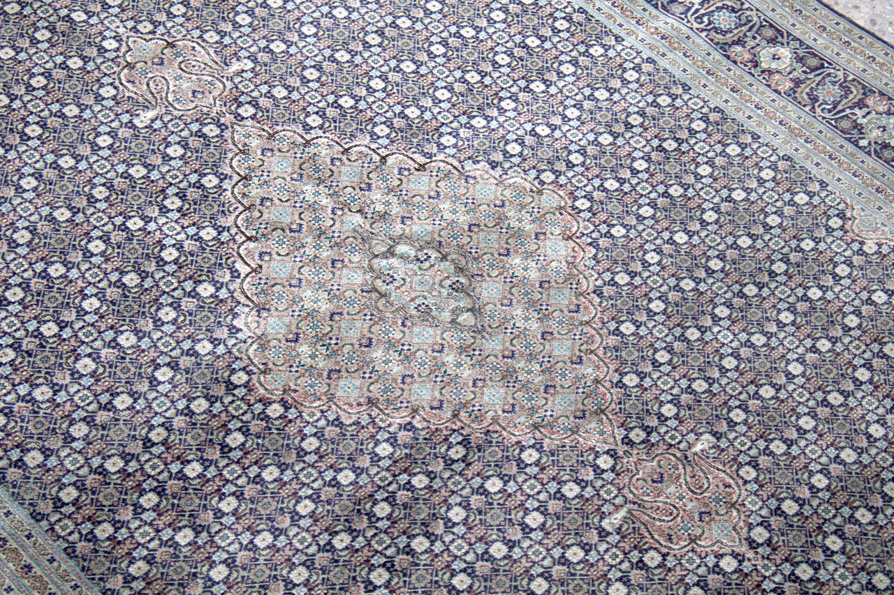 Persian Tabriz rug corner with pale central cartouche and blue floral pattern