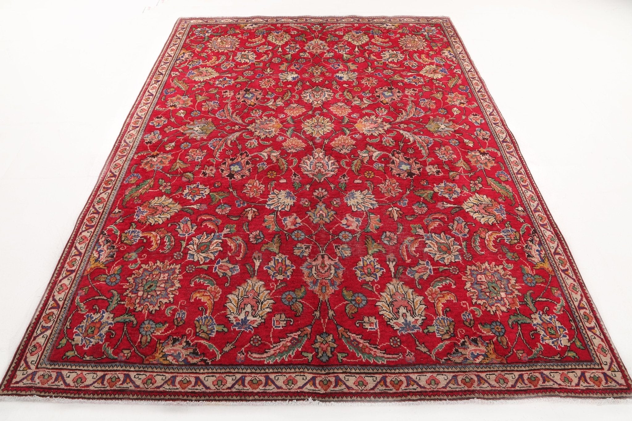 Red Persian Tabriz rug with central floral medallion and patterned border, full view
