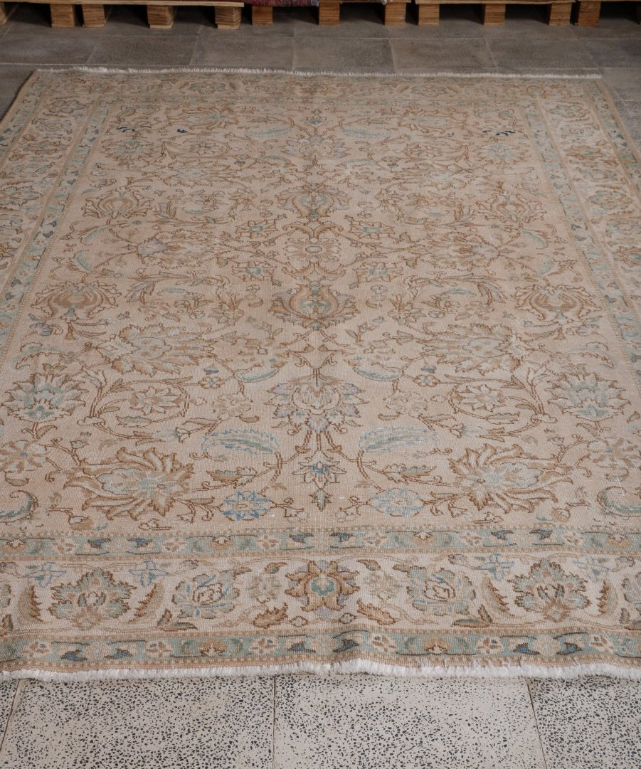 Persian Tabriz rug, large area view; beige field with ornate floral scrollwork and border.