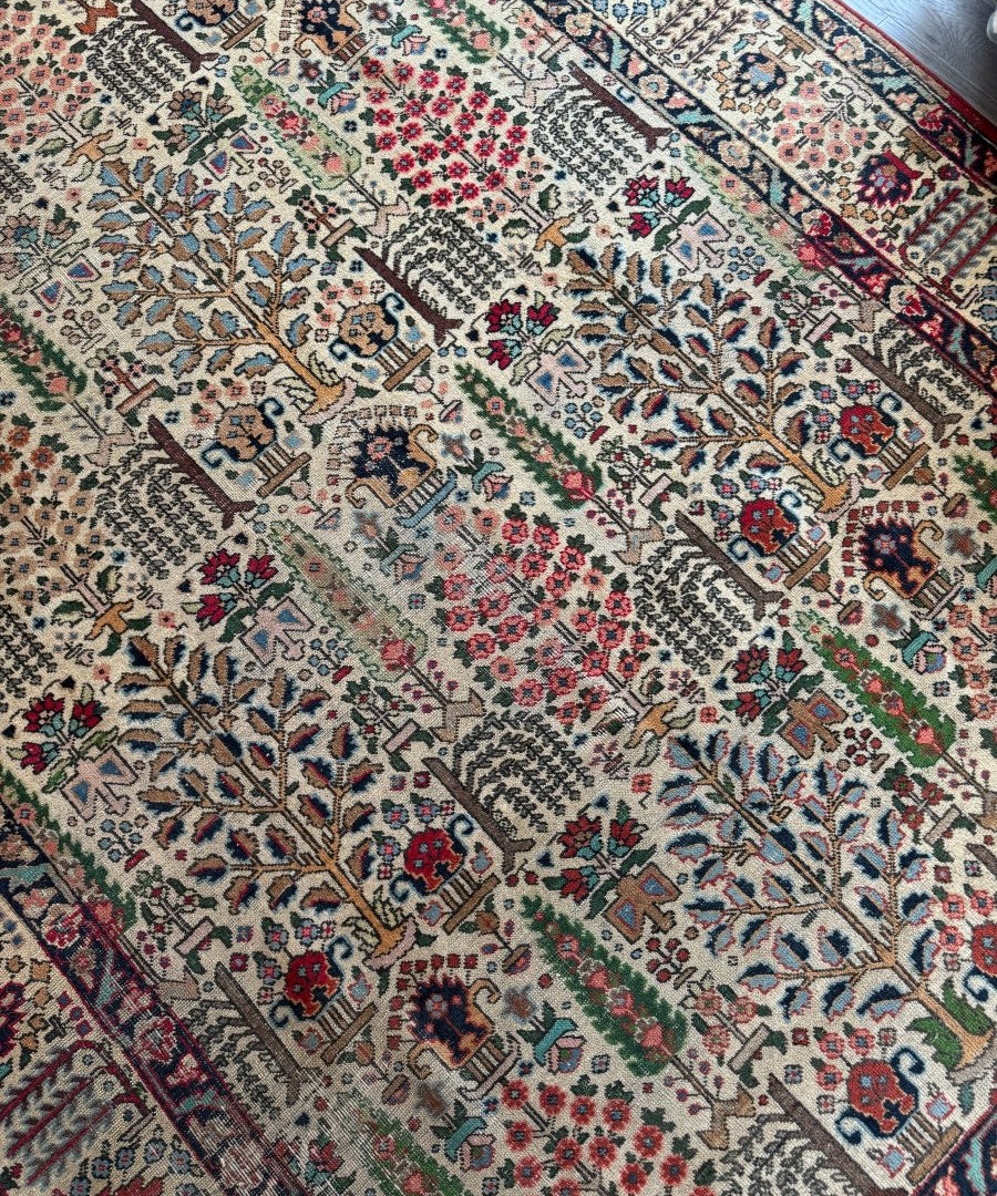 Persian Tabriz rug with cream field, navy and red floral medallions, and geometric border