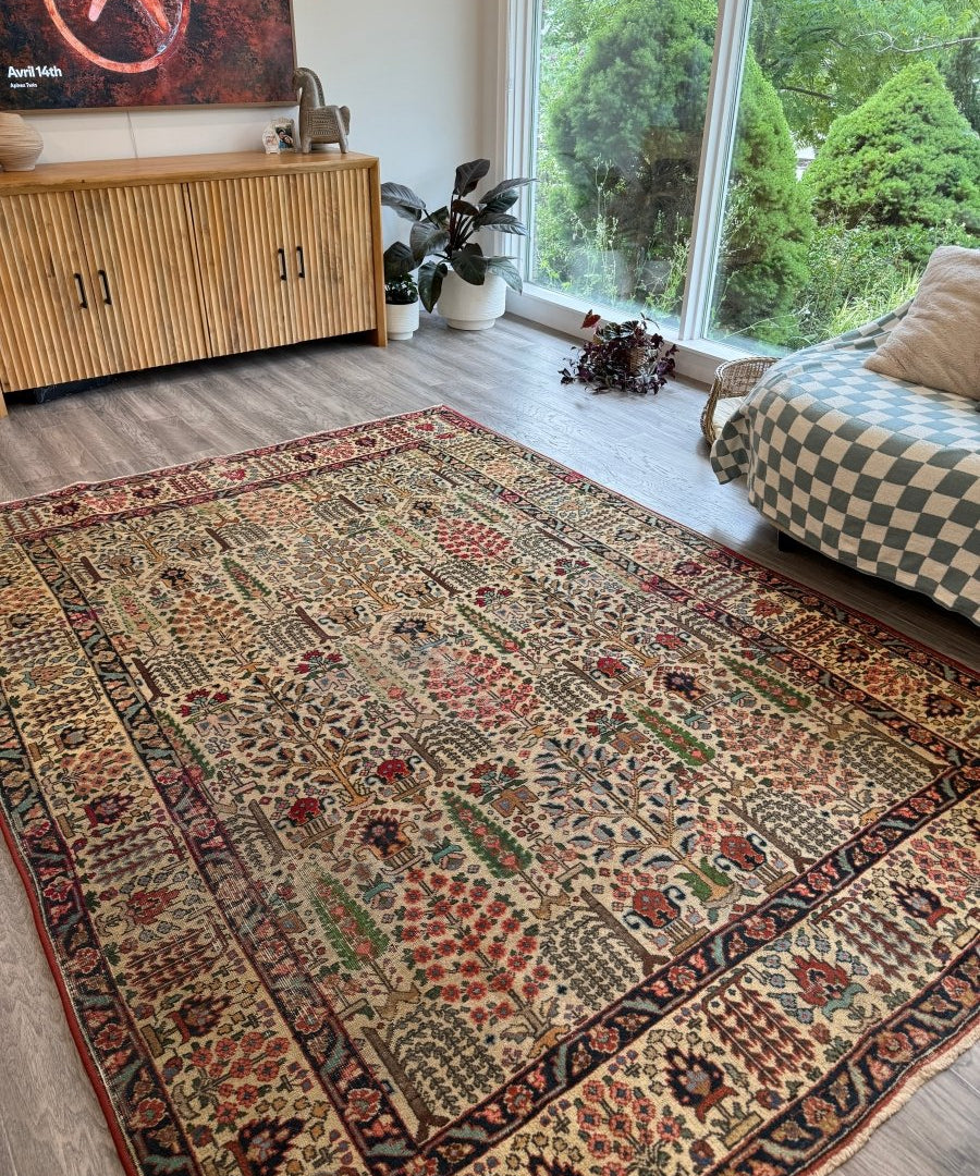 Persian Tabriz rug displayed on living room floor, cream pattern with red and blue medallions