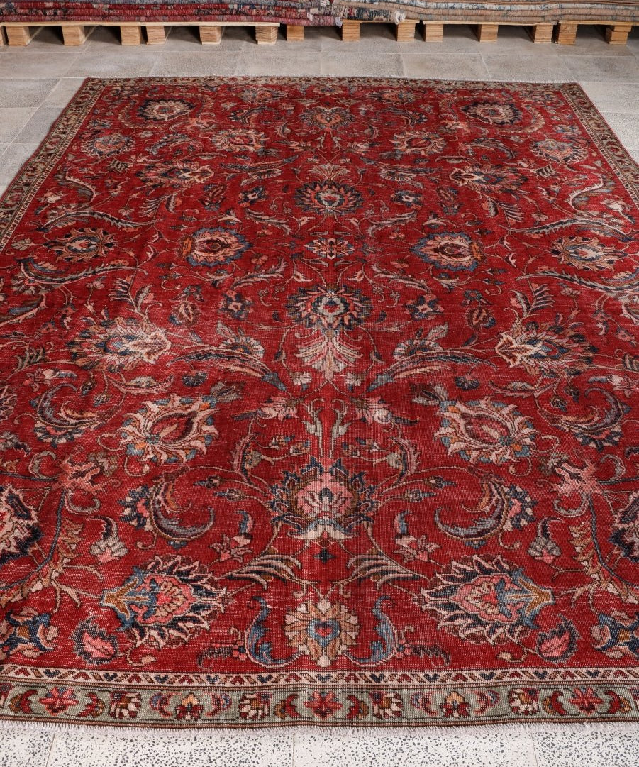 Red Persian-style area rug with ornate floral medallion and patterned border, full view.