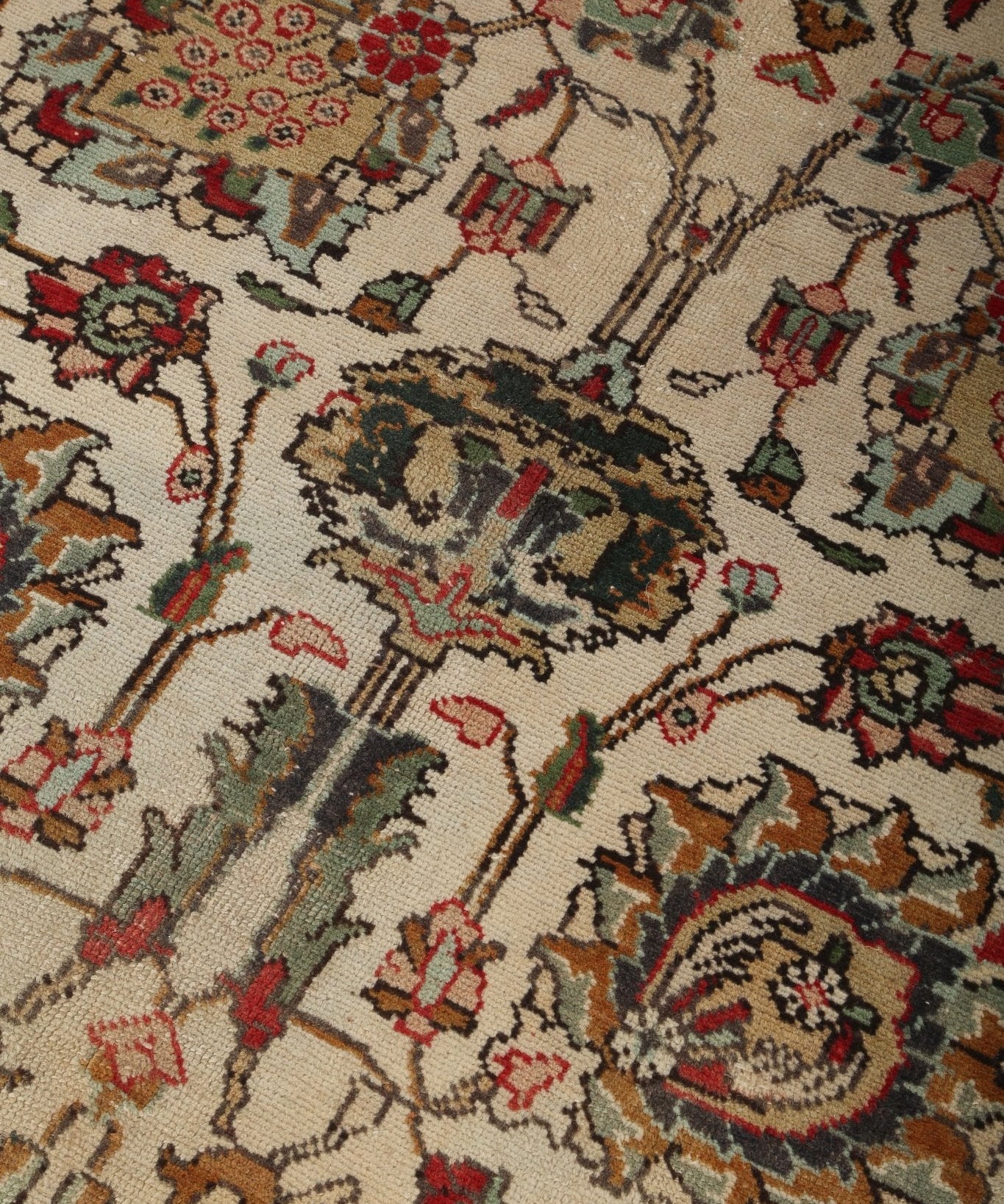 Persian-style Tabriz rug close-up with cream background and scattered medallions