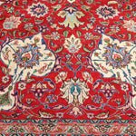Persian Tabriz rug close-up of red field, blue motifs, and cream scrollwork border