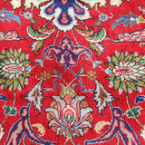 Persian Tabriz rug with red field and blue motifs, cream and green accents