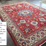 Persian Tabriz rug on floor with red center medallion and cream border motifs