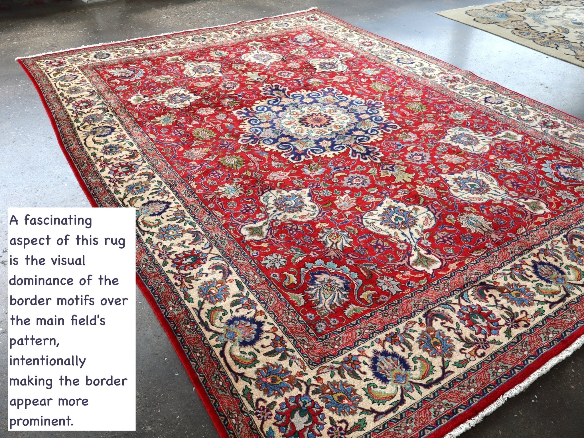 Persian Tabriz rug on floor with red center medallion and cream border motifs