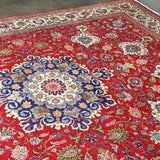 Persian Tabriz rug featuring red main field with ornate floral and rosette patterns