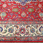 Persian Tabriz rug border detail with red background, blue outlines, and cream highlights