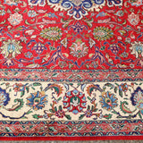Persian Tabriz rug border detail with red background, blue outlines, and cream highlights