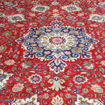Persian Tabriz rug with centered medallion, red with cream border and blue floral accents