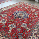 Persian Tabriz rug flat view, red field with central blue rosette medallion and border