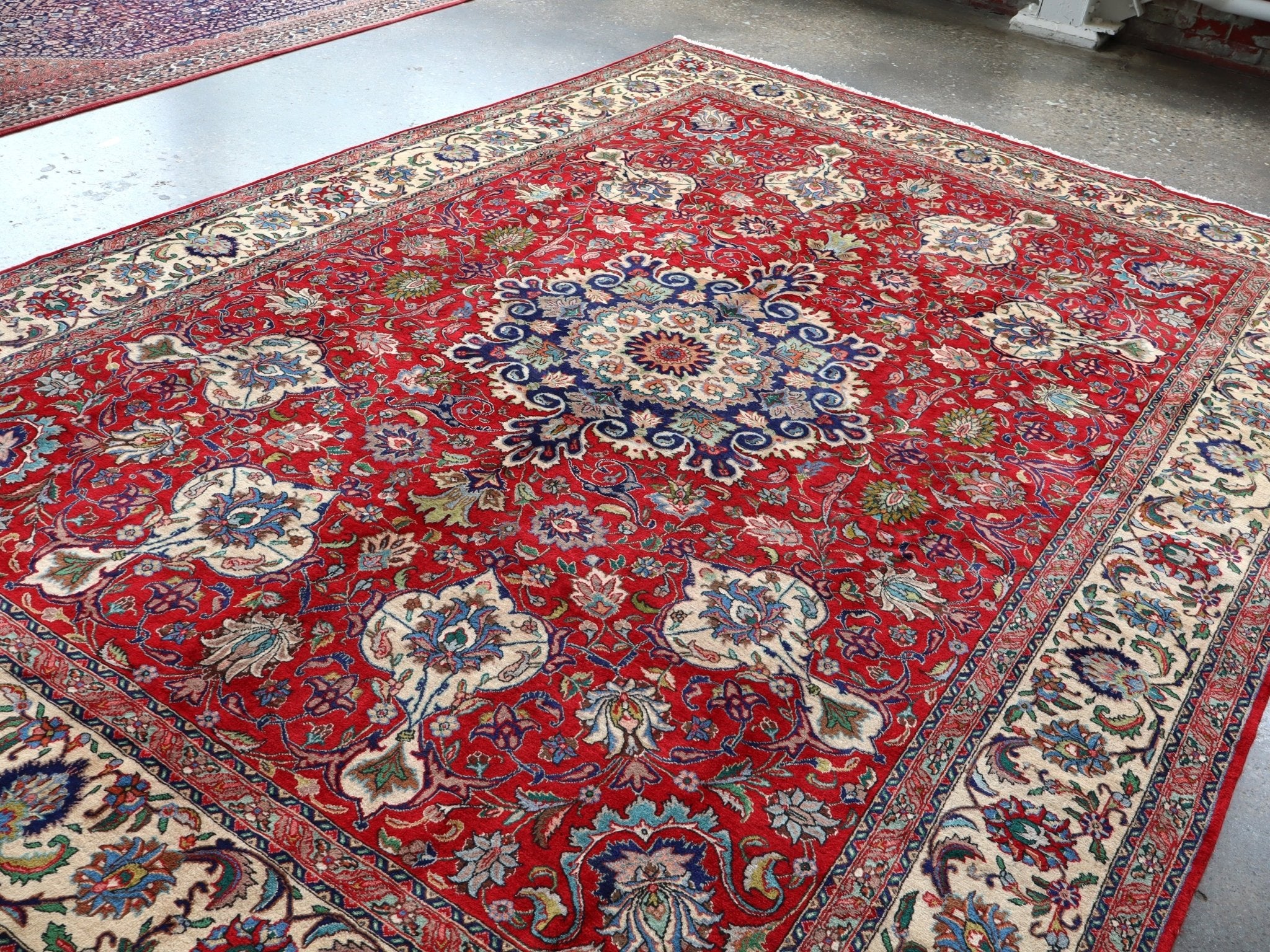 Persian Tabriz rug flat view, red field with central blue rosette medallion and border