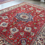 Persian Tabriz rug flat view, red field with central blue rosette medallion and border
