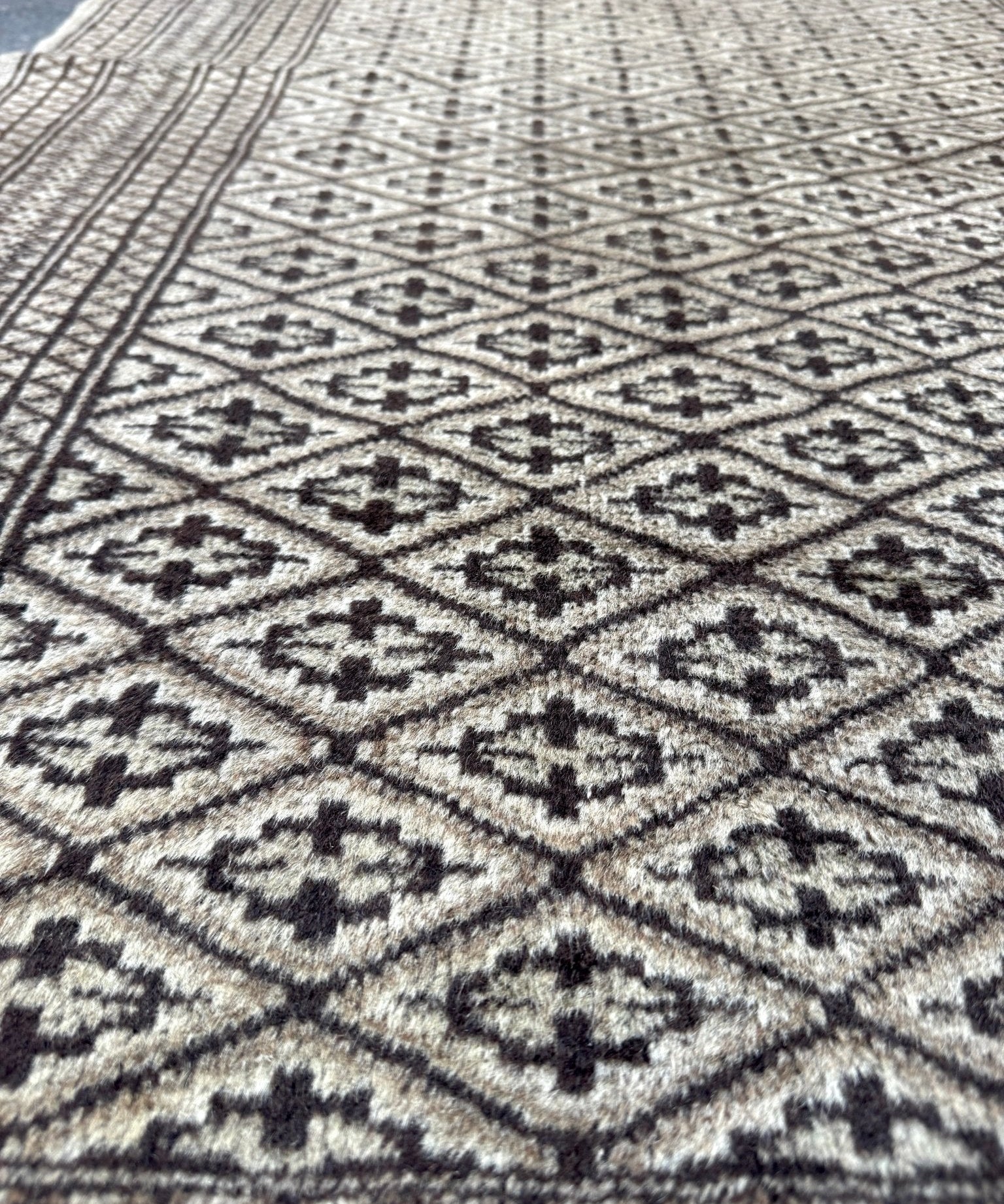 Persian Turkmen rug close-up featuring cross-and-diamond motifs across the weave